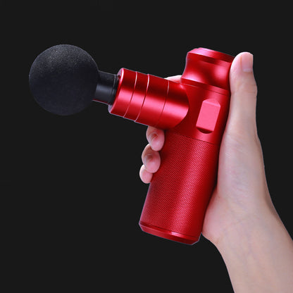 Red massage gun held in a hand against a black background