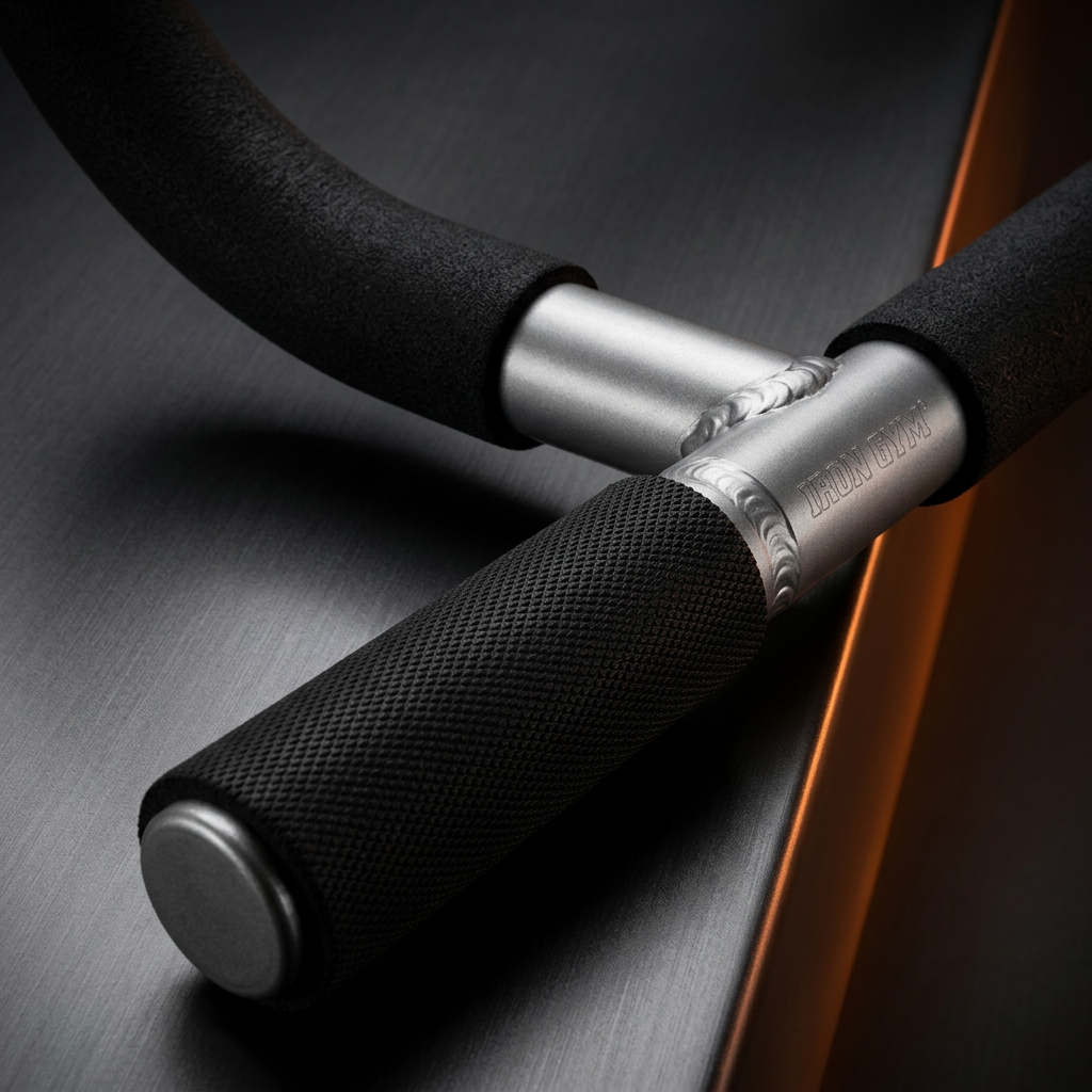 Close-up of a black foam exercise bar with textured black handles and silver metal ends on a dark brushed surface.