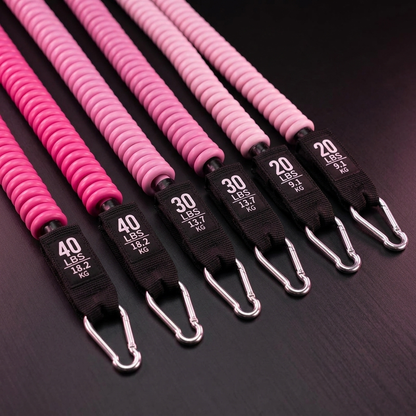 Pink resistance bands with labeled weight capacities on a dark background