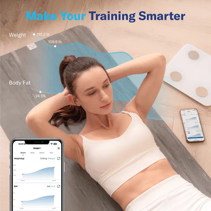 Woman lying on a fitness mat with a smartphone displaying health app, weight scale in the background.